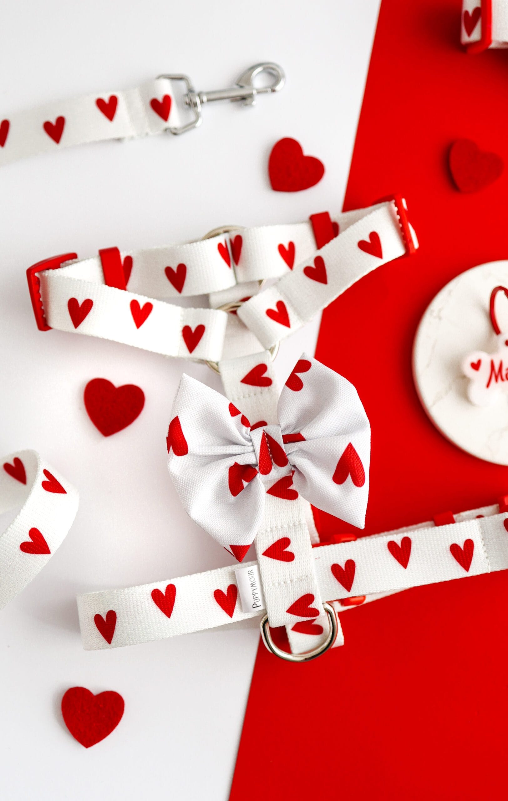 Białe szelki typu guard dla psa z kolekcji White Love Puppymour z przypiętą czerwoną kokardą na rzep.